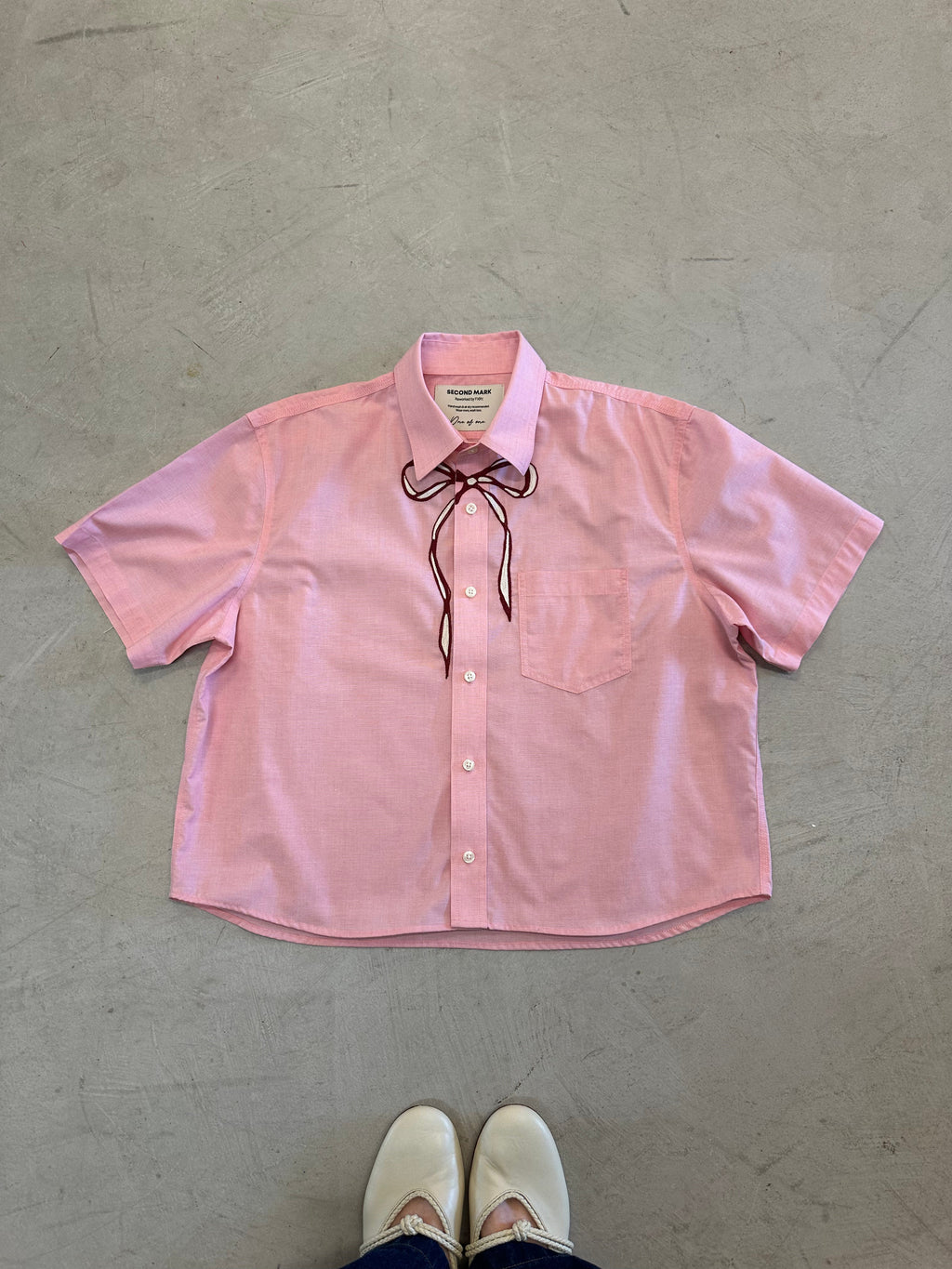 One-of-one vintage cropped short sleeve button-down in pink with hand-chainstitched maroon and ivory bow embroidery on the chest