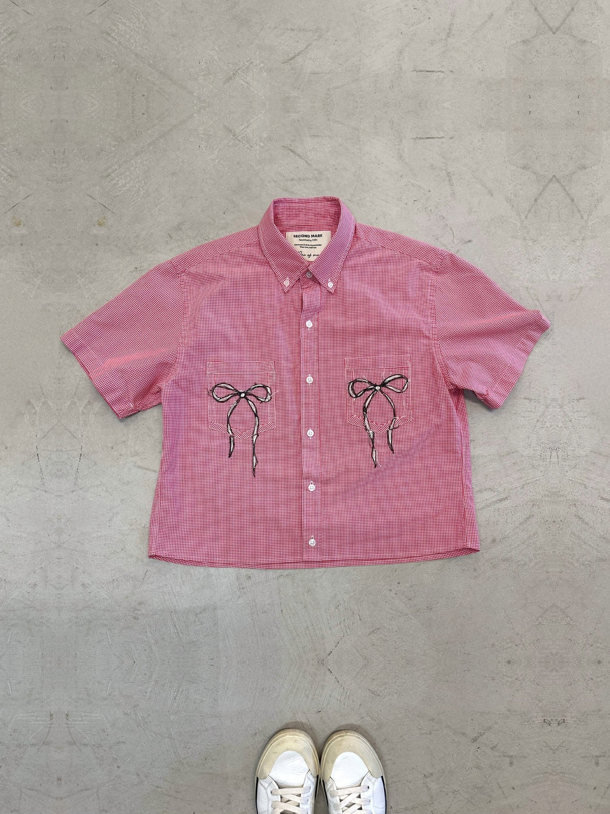One-of-one vintage cropped short sleeve button-down in red gingham with hand-chainstitched black and white bow embroidery on the chest pocket