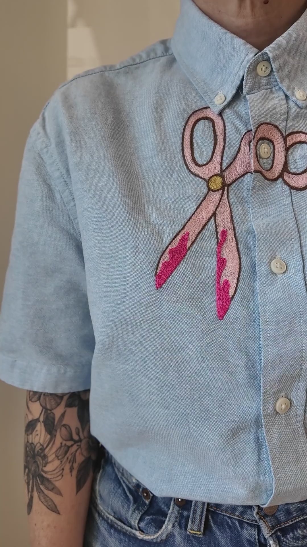 Try-on of the Emily Counts scissors across shirt